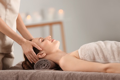 Photo of Beautiful young woman enjoying massage in spa salon