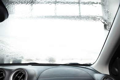 Wet automobile windshield at car wash, view from inside