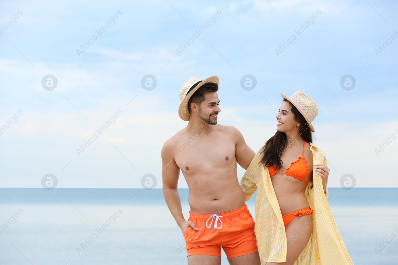 Photo of Happy young couple walking together on beach