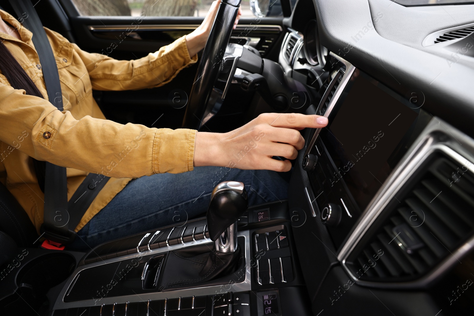 Photo of Woman using navigation system while driving her car, closeup