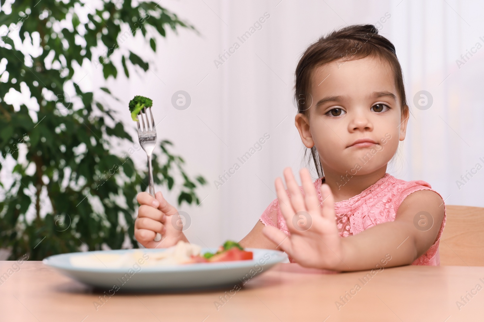 Photo of Cute little girl refusing to eat her breakfast at home