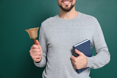 Photo of Teacher with school bell near chalkboard, closeup