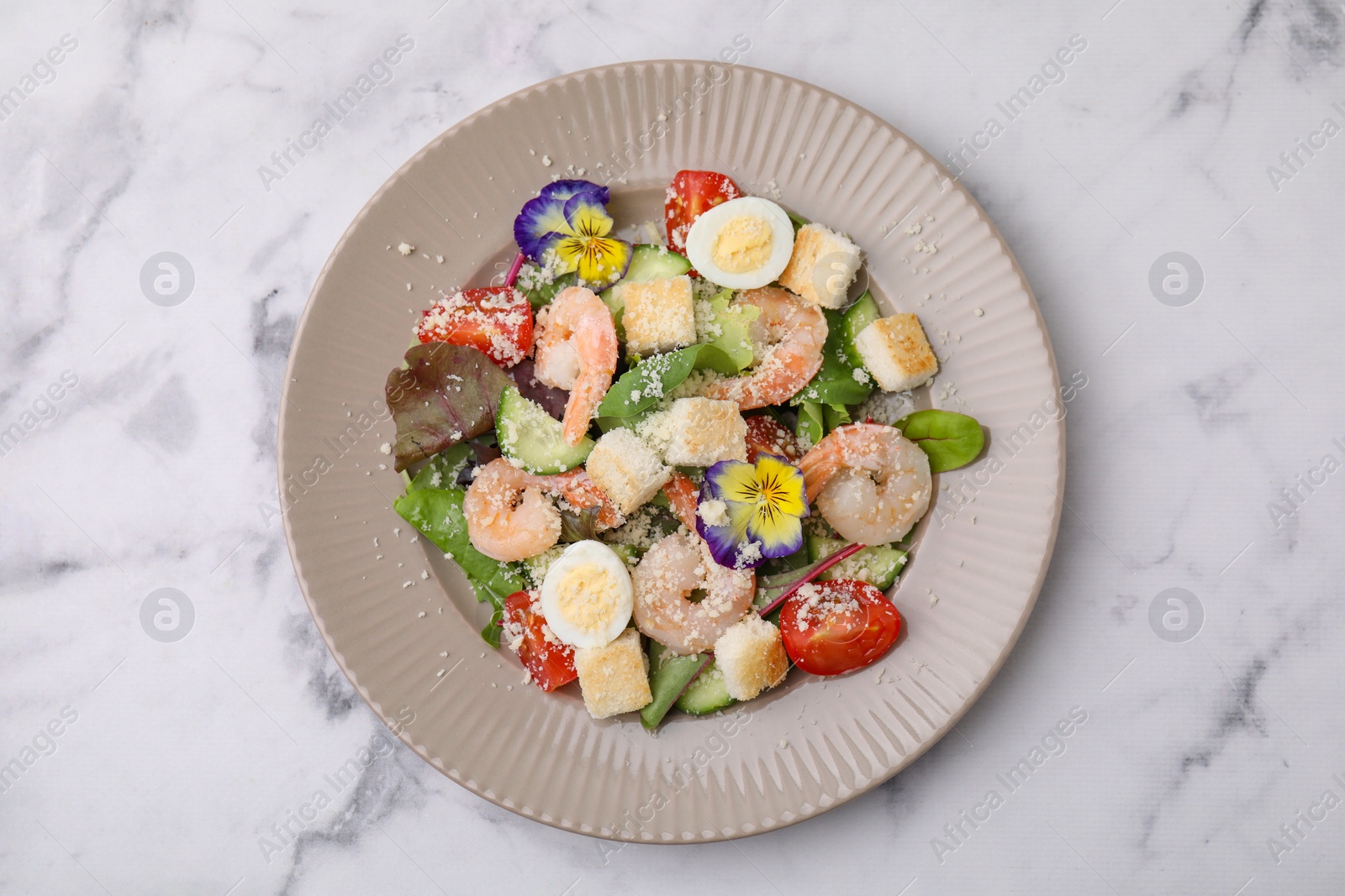 Photo of Delicious Caesar salad with shrimps on white marble table, top view