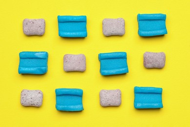 Different bubble gums on yellow background, flat lay