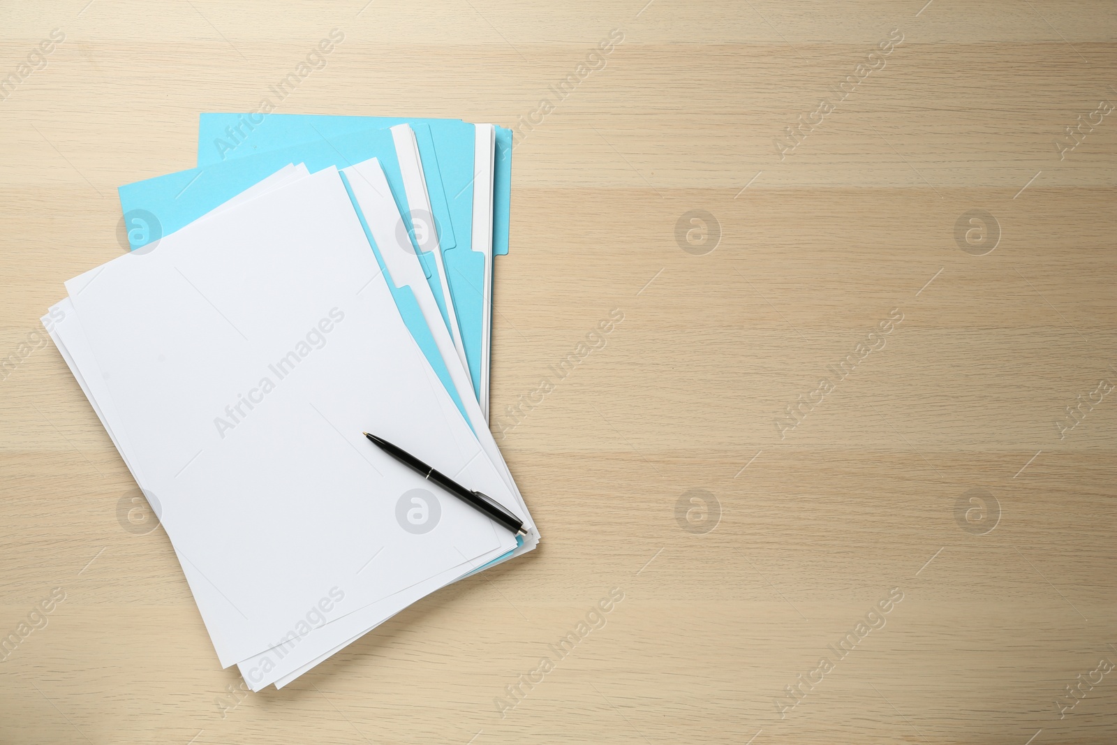 Photo of Turquoise files with blank sheets of paper and pen on wooden table, top view. Space for text