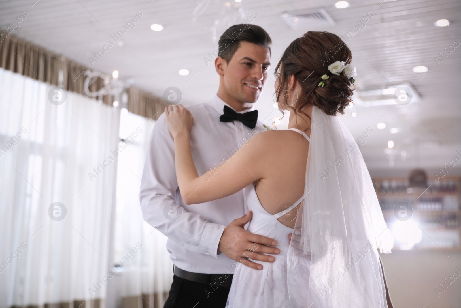 Photo of Happy newlywed couple dancing together in festive hall