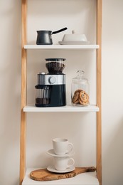 Photo of Modern coffee grinder on shelving unit in kitchen