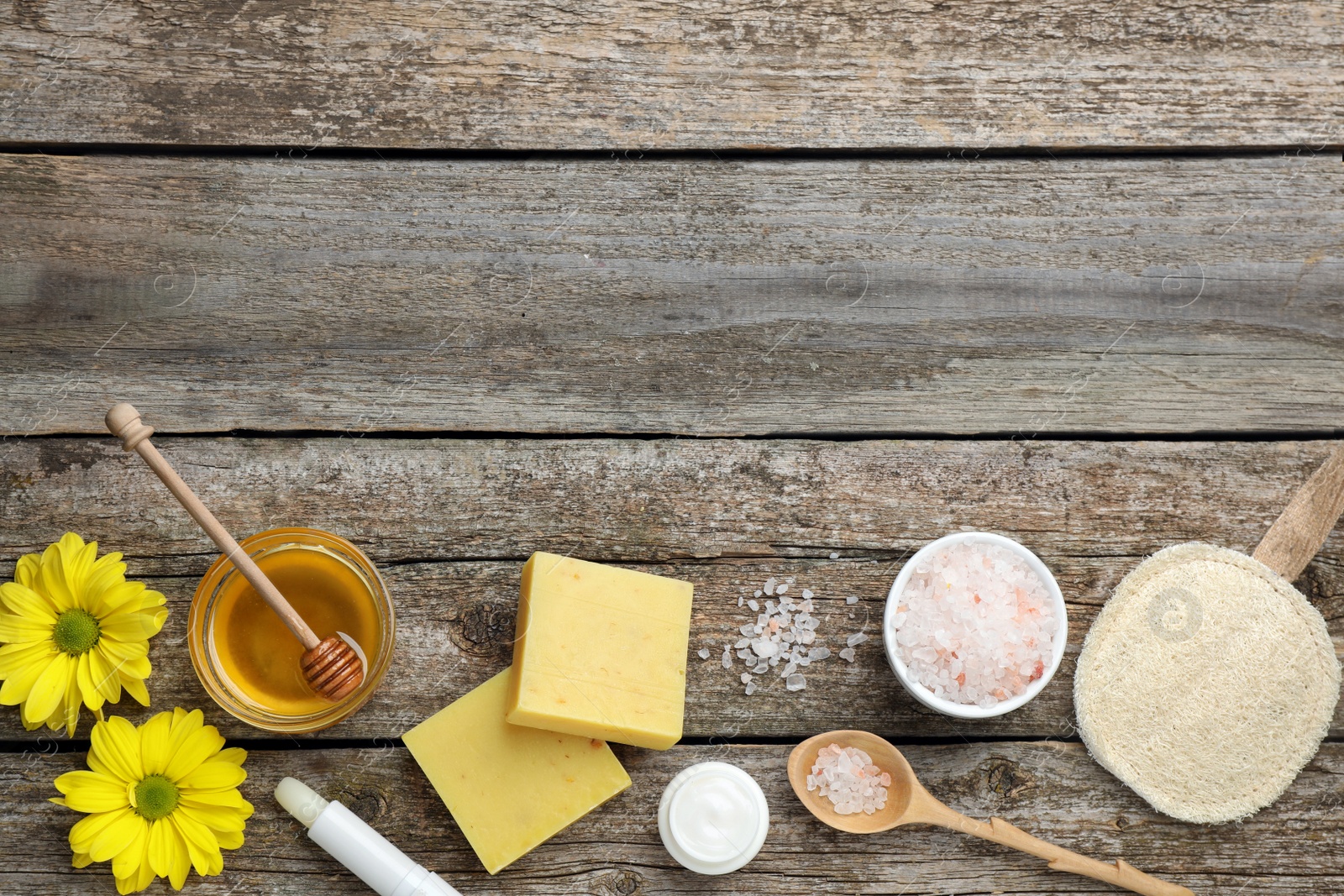 Photo of Flat lay composition with beeswax and cosmetic products on wooden table. Space for text