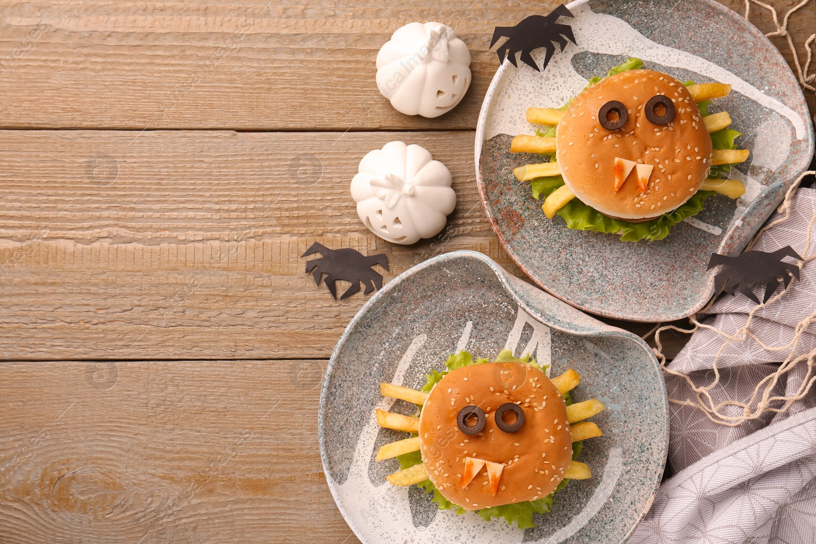 Photo of Flat lay composition with tasty monster sandwiches for Halloween party on wooden table. Space for text