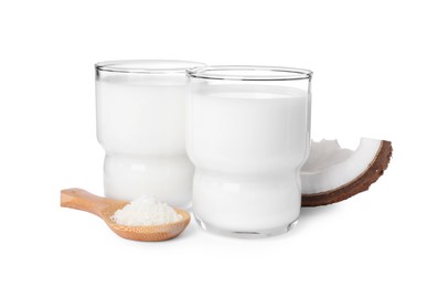 Glasses of delicious coconut milk, spoon with flakes and coconut isolated on white