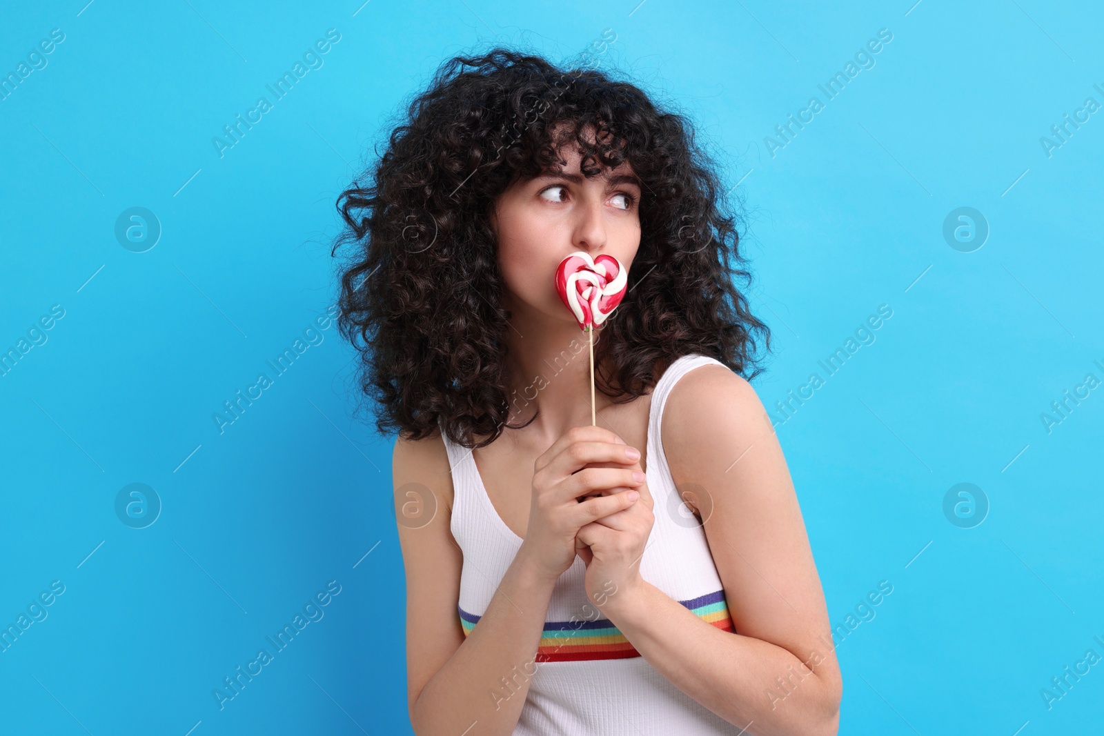 Photo of Beautiful woman with lollipop on light blue background