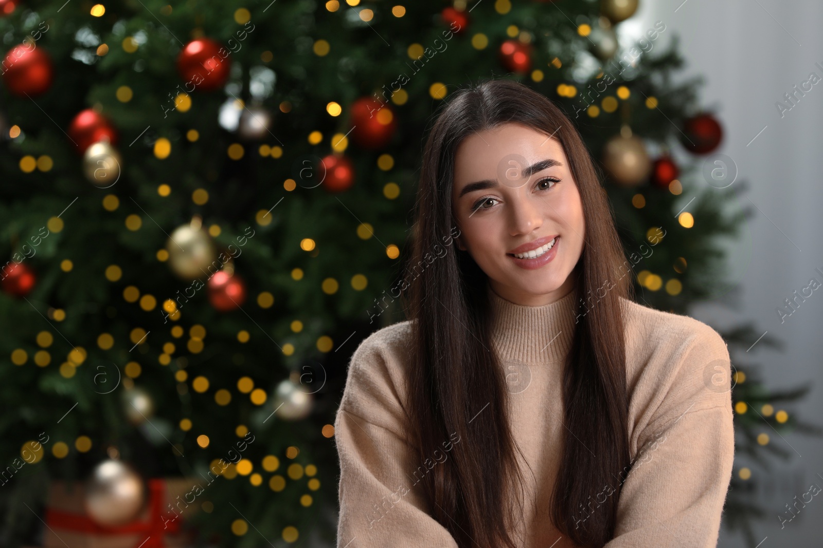 Photo of Portrait of happy woman near Christmas tree. Space for text