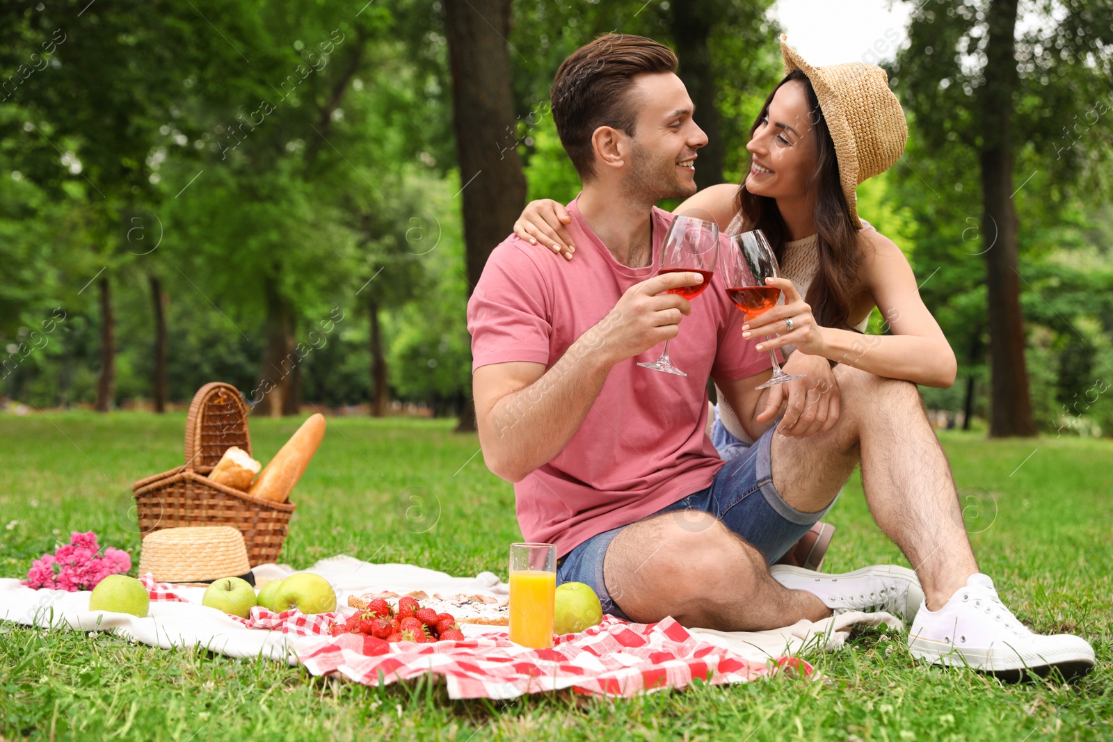 Photo of Happy young couple having picnic in park on summer day