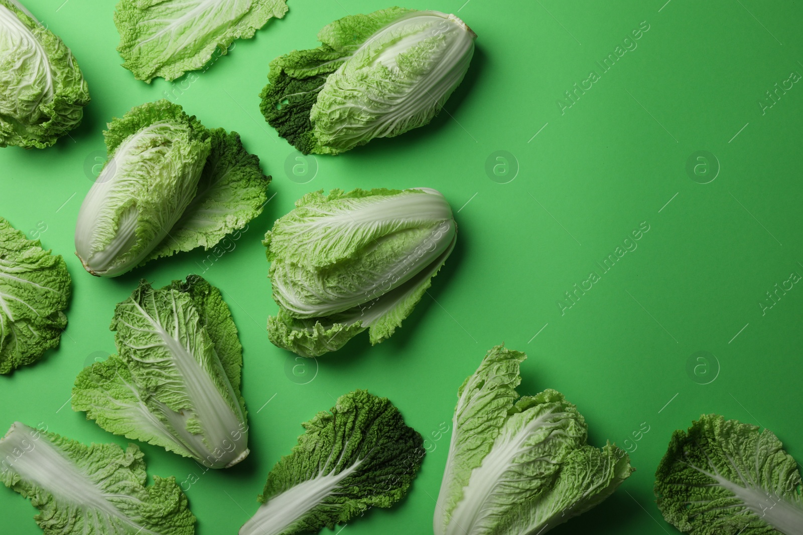 Photo of Fresh ripe Chinese cabbages on light green background, flat lay. Space for text