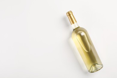 Photo of Bottle of expensive white wine on light background, top view. Space for text