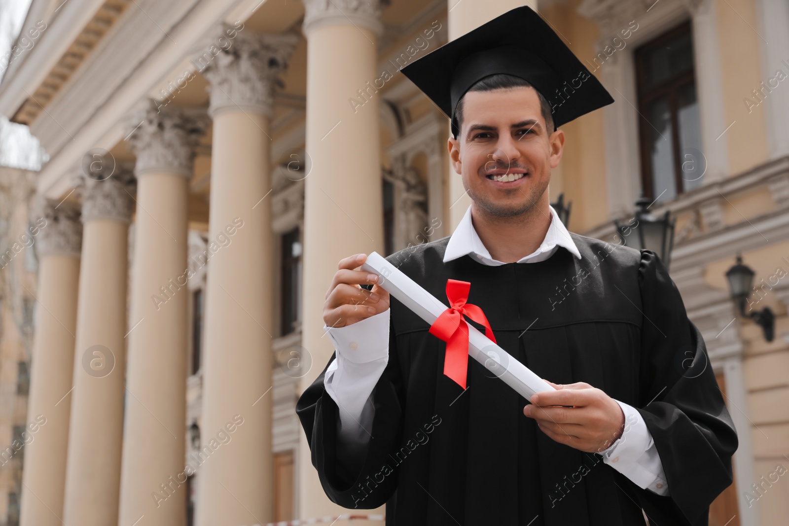 Photo of Happy student with diploma after graduation ceremony outdoors. Space for text