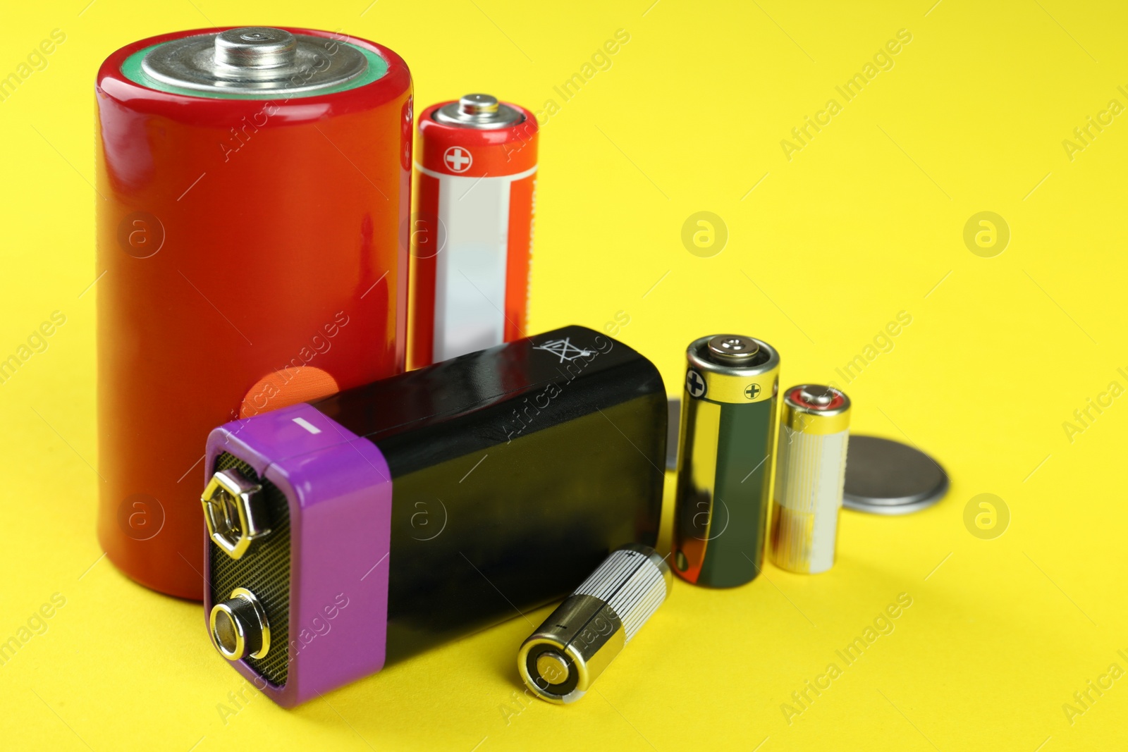 Image of Different types of batteries on yellow background