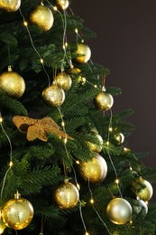 Beautifully decorated Christmas tree on brown background, closeup