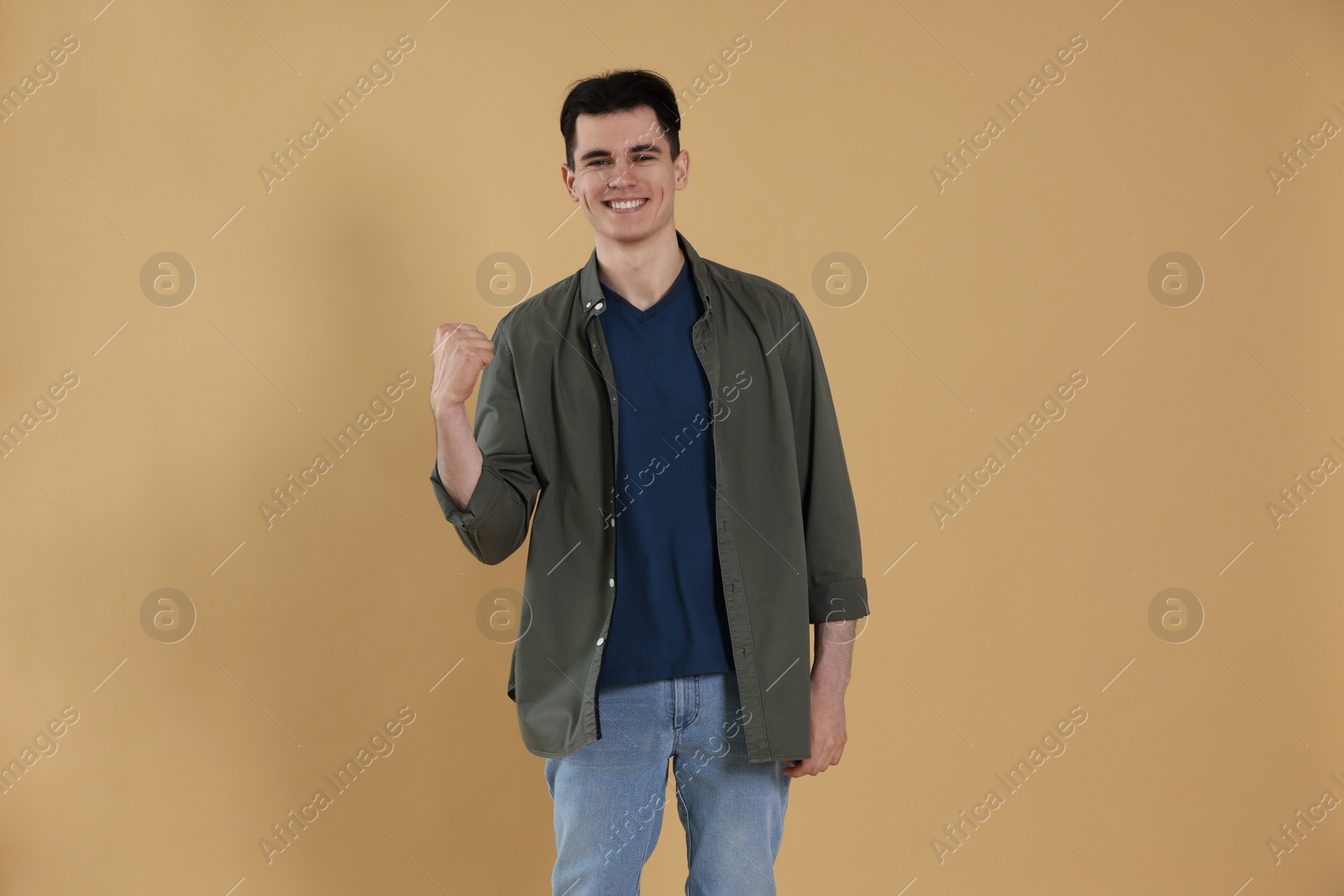 Photo of Portrait of happy young man on beige background