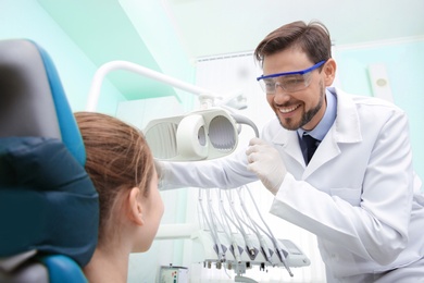 Professional dentist working with little patient in modern clinic