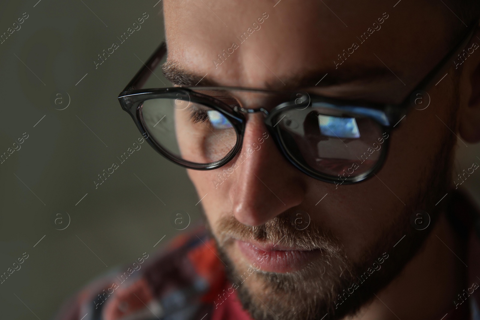 Photo of Young man wearing glasses on color background, closeup. Ophthalmology service