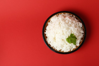 Photo of Bowl of boiled rice on color background, top view with space for text