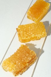 Natural honeycombs with tasty honey on white table, above view