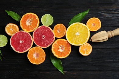 Different citrus fruits on wooden background, flat lay