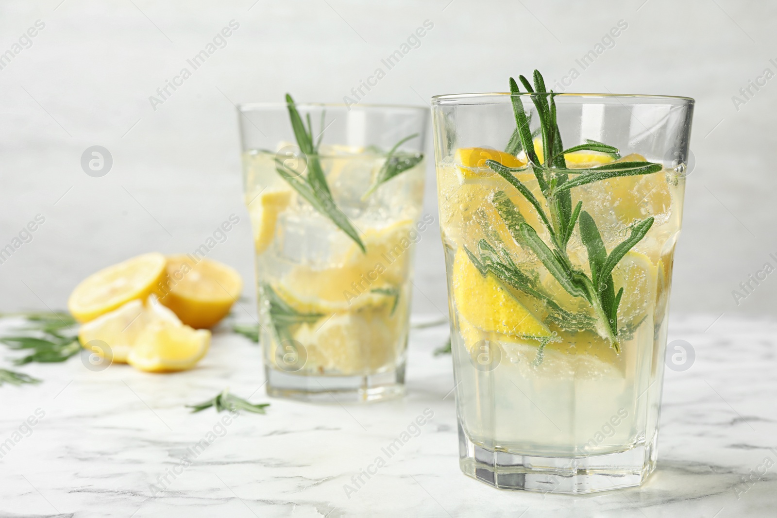 Photo of Glasses of refreshing lemonade on marble table, space for text. Summer drink