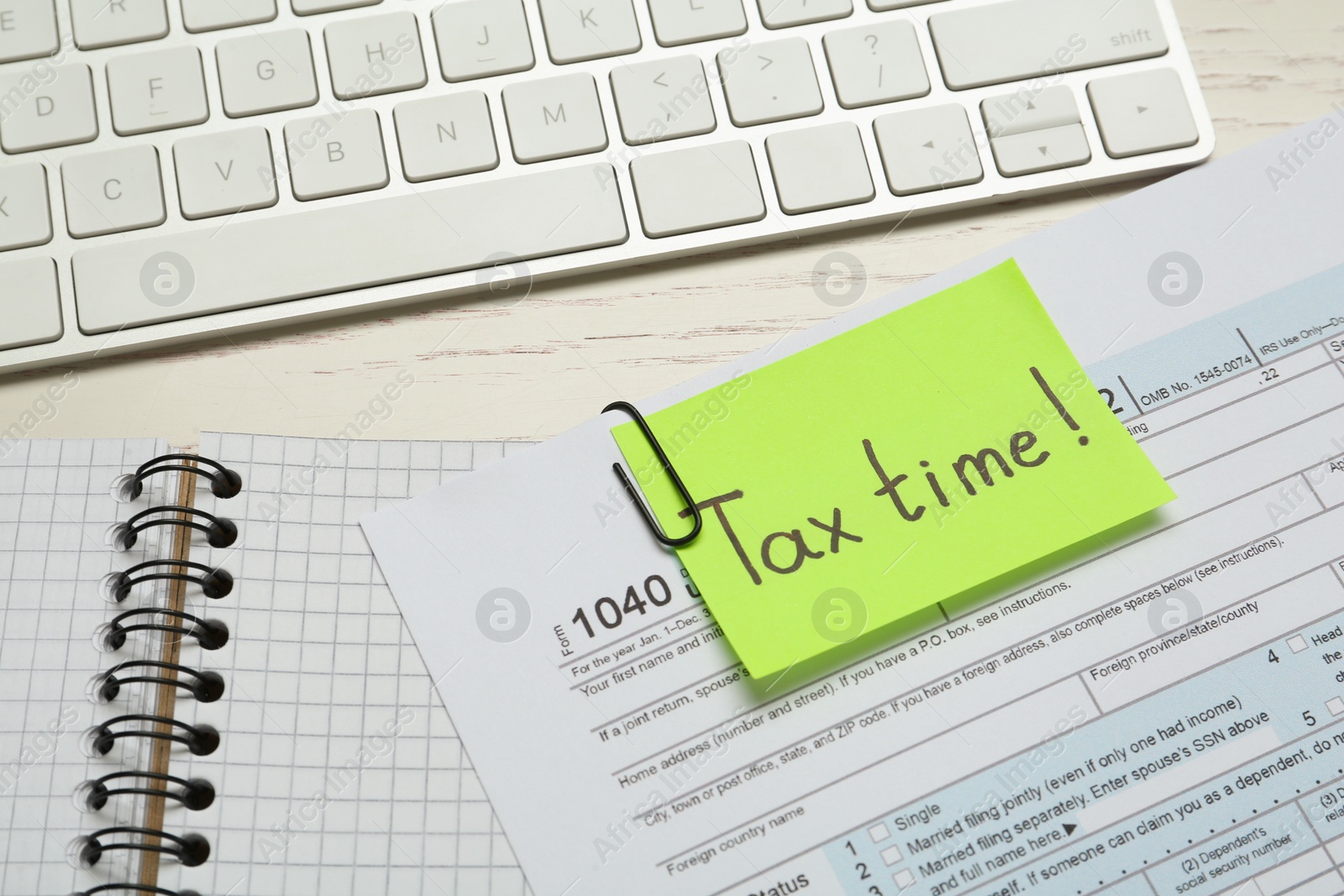 Photo of Reminder note with words Tax Time, documents and computer keyboard on white wooden table, closeup