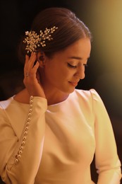 Photo of Young bride wearing beautiful wedding dress on black background