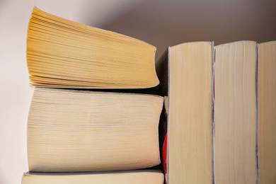 Photo of Collection of different books near white wall, closeup