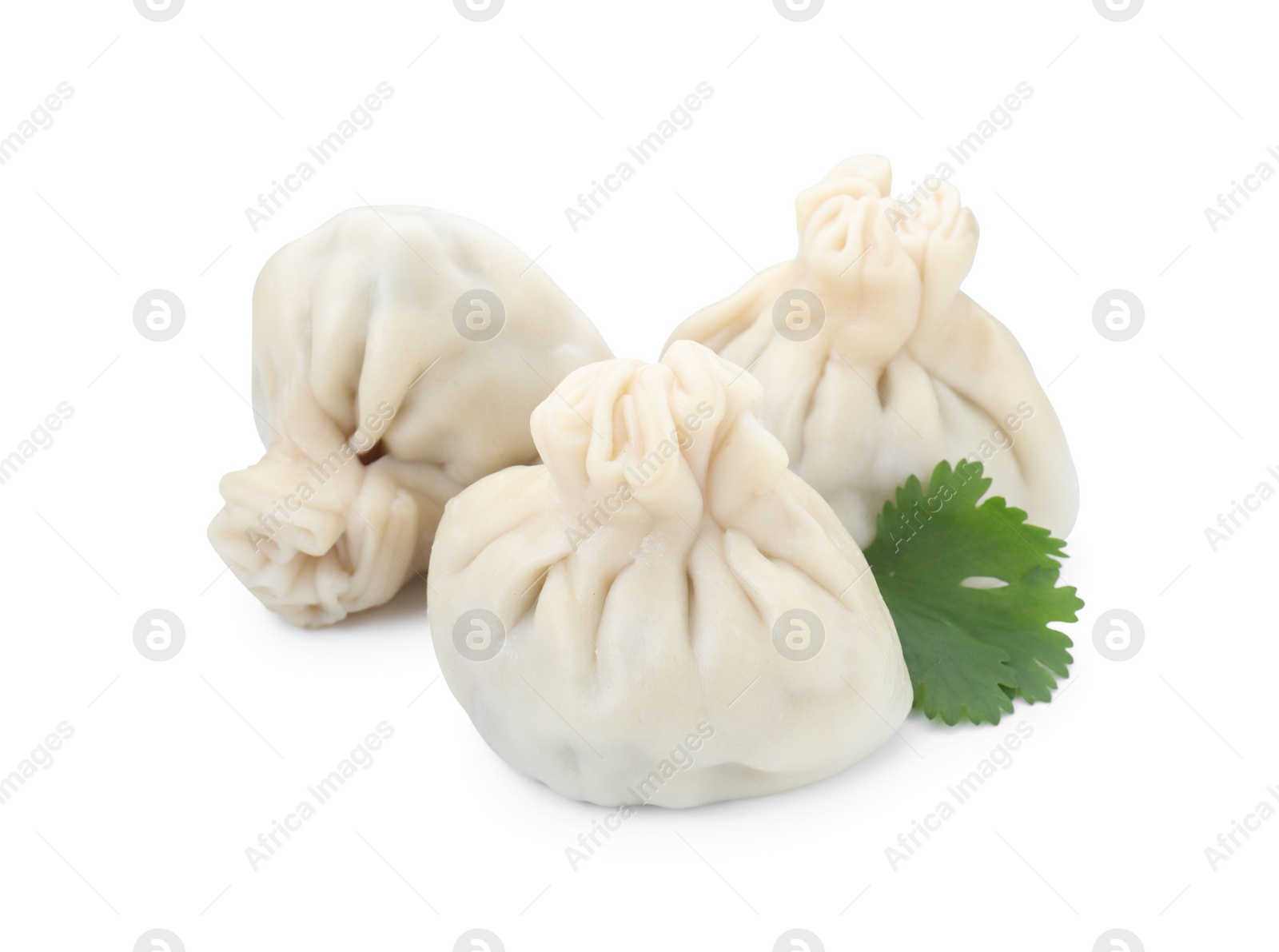 Photo of Three tasty khinkali (dumplings) and parsley isolated on white. Georgian cuisine