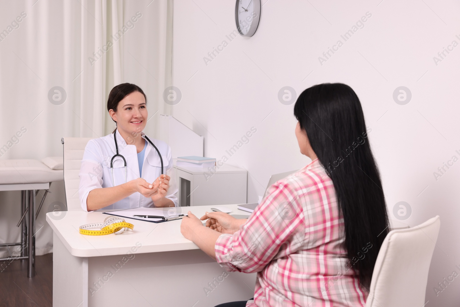 Photo of Overweight woman consulting with nutritionist in clinic