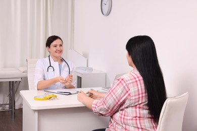 Photo of Overweight woman consulting with nutritionist in clinic