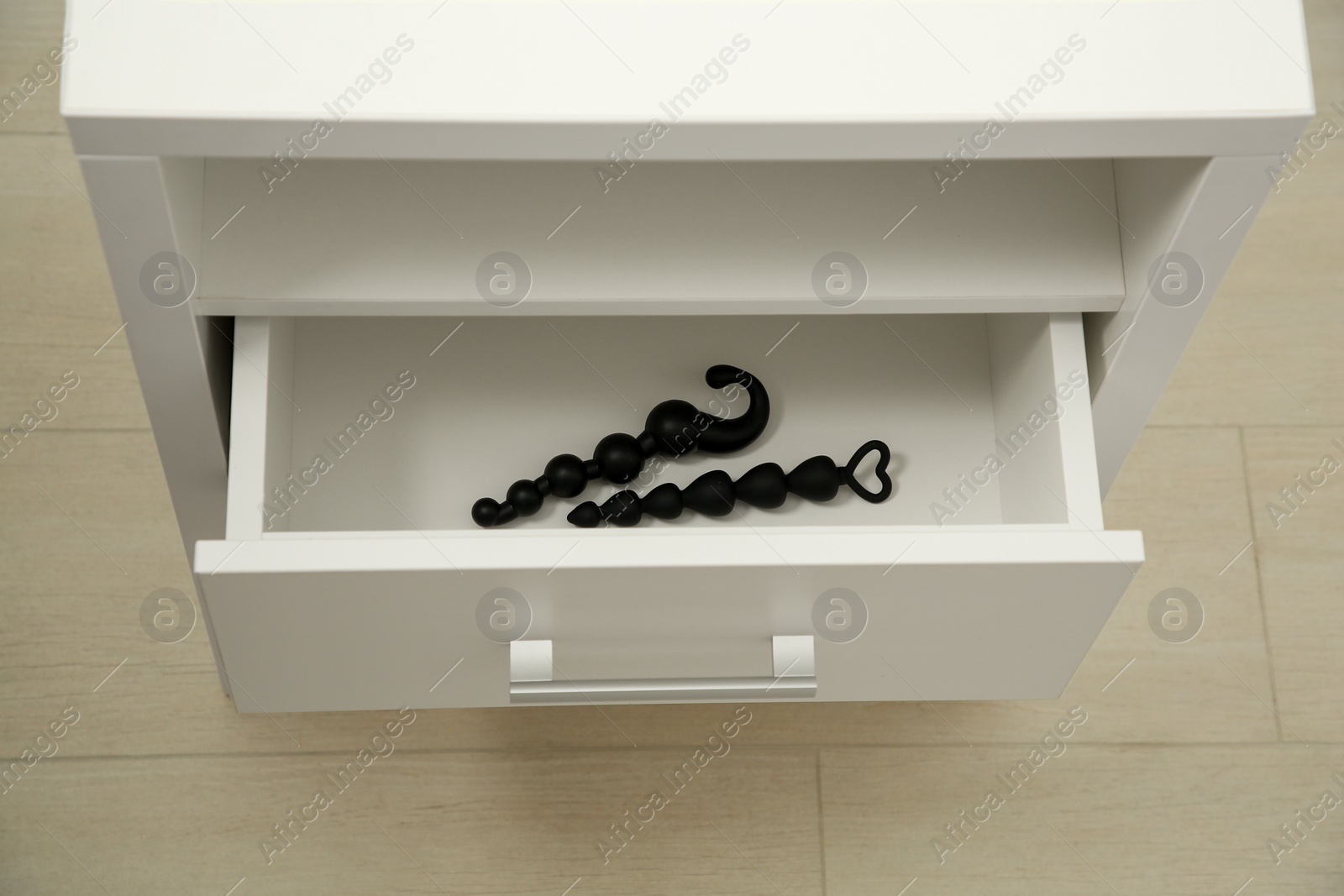 Photo of Black anal beads in drawer indoors. Sex toys