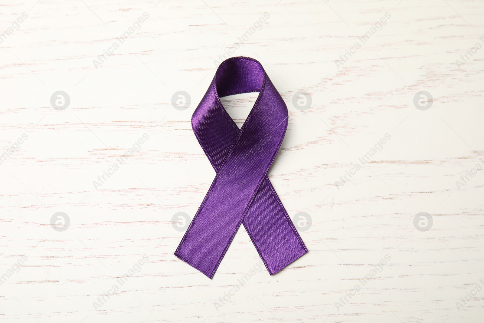 Photo of Purple ribbon on white wooden background, top view. Domestic violence awareness