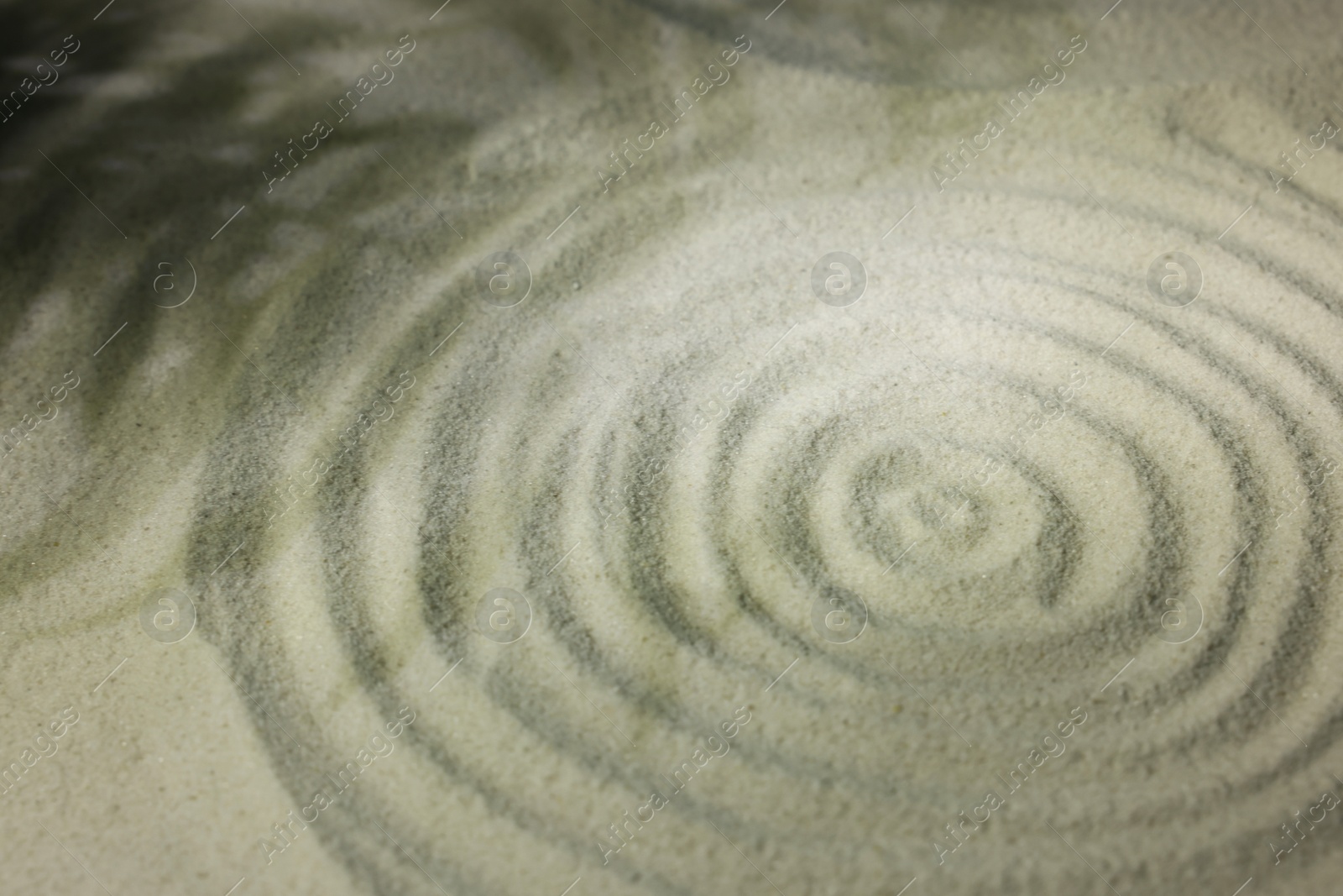 Photo of Beautiful spiral and shadows of leaves on sand, closeup. Zen garden