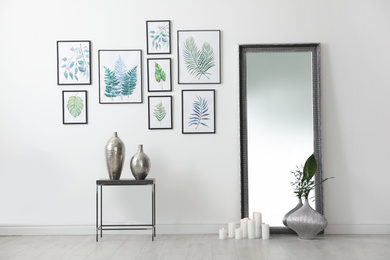 Photo of Living room interior with paintings of tropical leaves on white wall