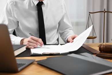 Photo of Lawyer working with documents at wooden table indoors, closeup