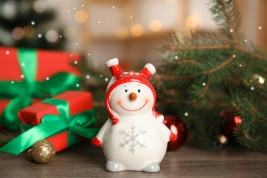 Christmas composition with decorative snowman on wooden table