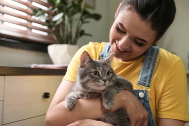 Young woman with cute cat at home. Pet and owner