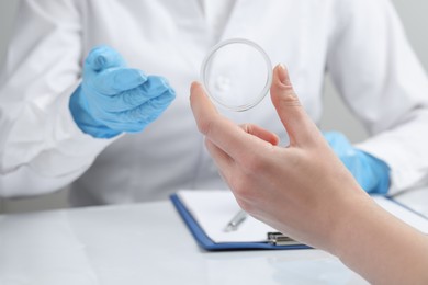 Woman holding diaphragm vaginal contraceptive ring at the doctor's appointment, closeup