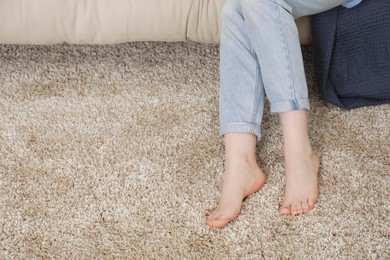 Photo of Woman on soft brown carpet at home, closeup. Space for text