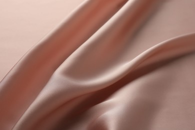 Crumpled pink silk fabric as background, top view