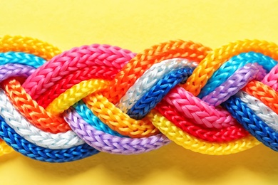 Photo of Braided ropes on color background, top view. Unity concept