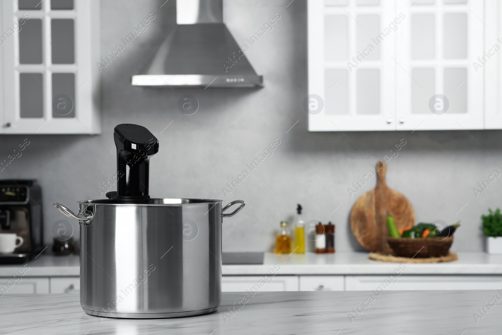 Photo of Pot with sous vide cooker on table in kitchen, space for text. Thermal immersion circulator