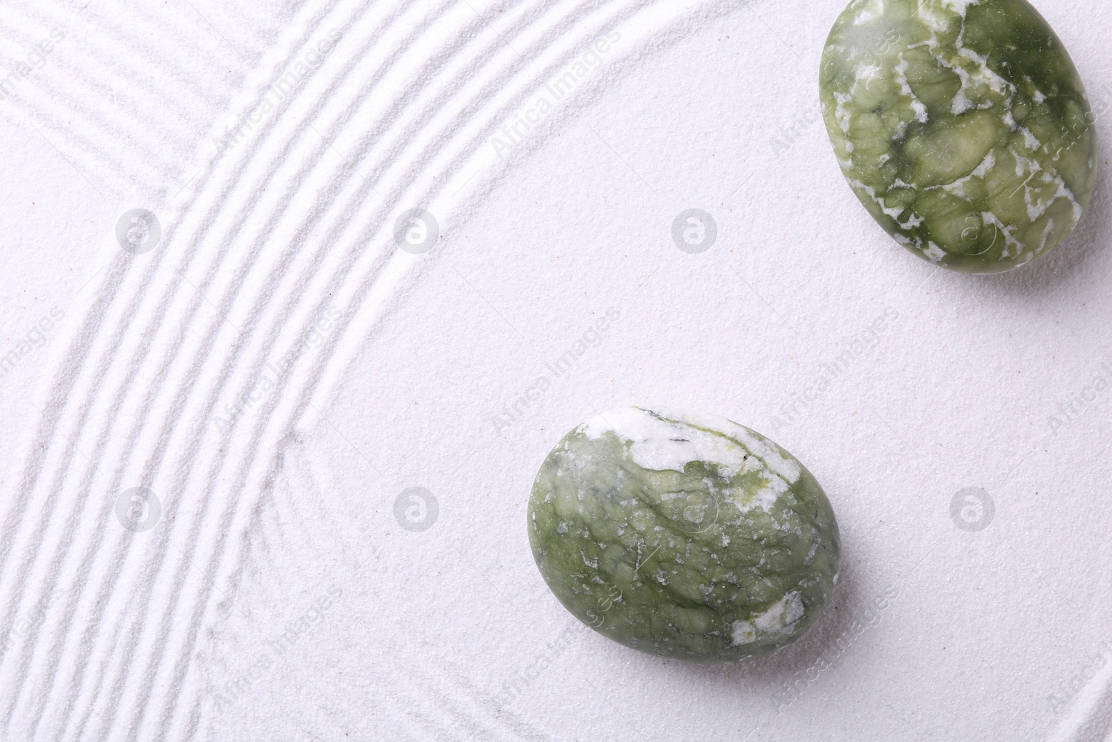 Photo of Stones on sand with pattern, flat lay. Zen concept