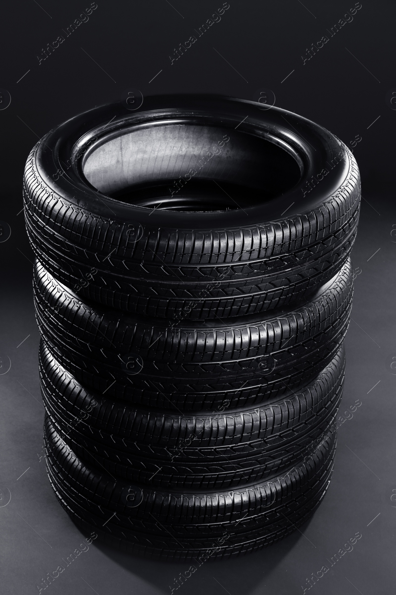 Photo of Stack of car tires on black background