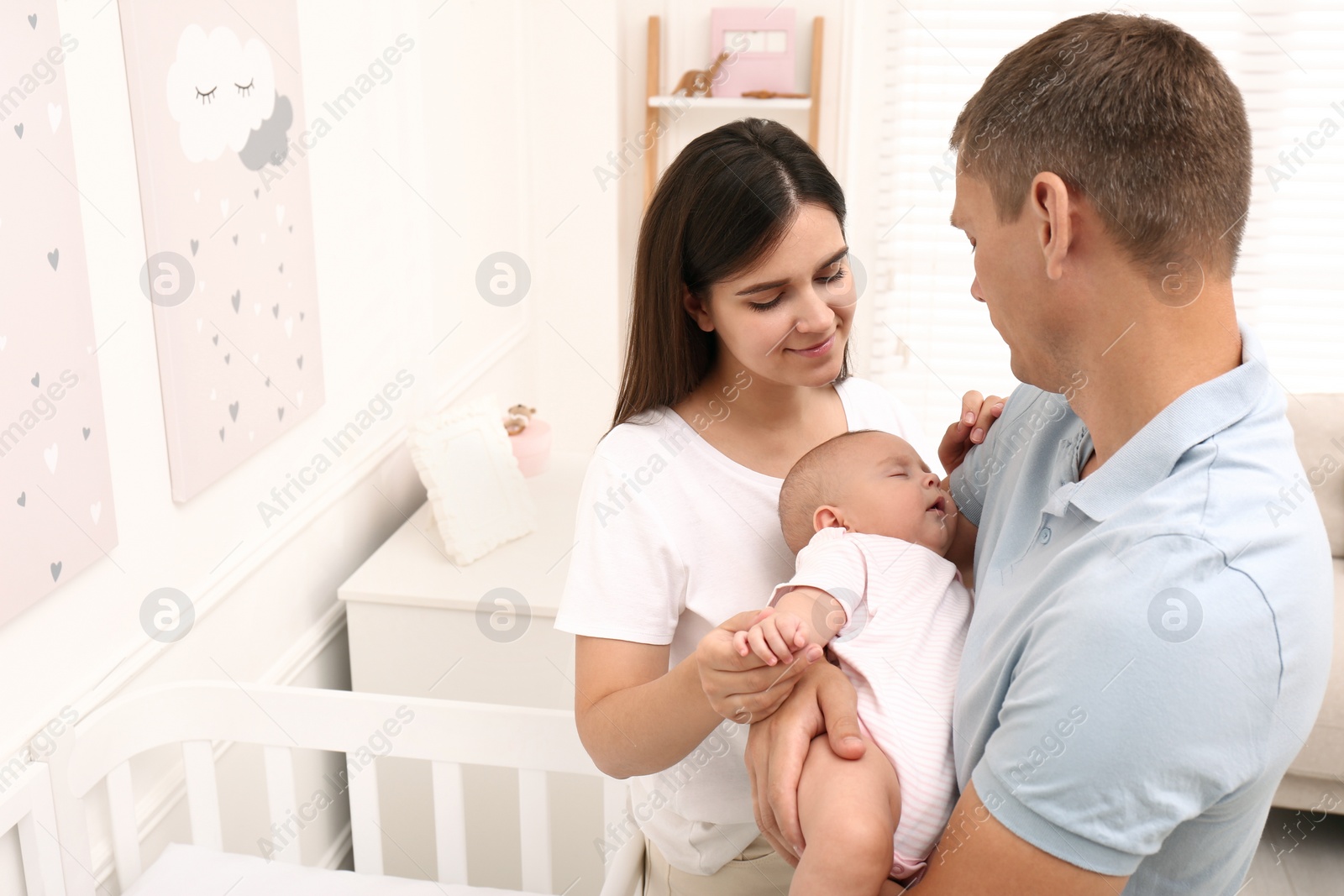 Photo of Happy family with their sleeping baby at home. Space for text